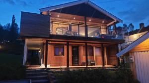 a house with a large glass facade at night at Apartment, 4km fra Tromsøsentrum. flyplass 1.71km. in Tromsø