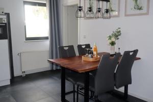 a dining room with a wooden table and chairs at Die Idyllische - Ferienwohnung mit Garten und Sauna in Kleve