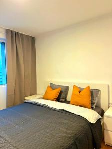 a bedroom with a bed with orange pillows at Up in Bucharest in Bucharest