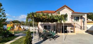 a house with a pergola with a table and chairs at Къща за гости Етерна - Guest house Eterna in Starosel