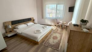 a bedroom with a large bed with white sheets and pillows at Къща за гости Етерна - Guest house Eterna in Starosel