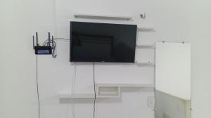 a flat screen tv hanging on a white wall at Flat Shopping Amarração N - 129 in Luis Correia