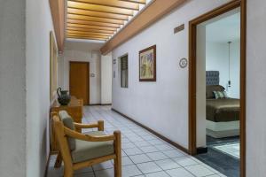 ein Flur mit einem Stuhl und ein Schlafzimmer in der Unterkunft Hotel Gala Oaxaca in Oaxaca de Juárez