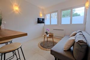 a living room with a couch and a table at La confidence in Périgueux