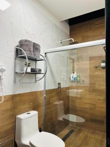 a bathroom with a toilet and a glass shower at Casa Don José TULIPANES Suite in Oaxaca City
