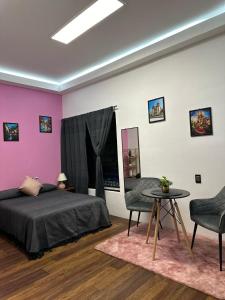 a bedroom with a bed and a table and chairs at Casa Don José TULIPANES Suite in Oaxaca City