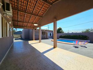 Casa com piscina e churrasq prox paraguai itaipu في فوز دو إيغواسو: فناء في الهواء الطلق مع مظلة وحمام سباحة