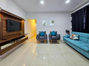 Casa com piscina e churrasq prox paraguai itaipu في فوز دو إيغواسو: غرفة معيشة مع اثنين من الأرائك الزرقاء وتلفزيون بشاشة مسطحة