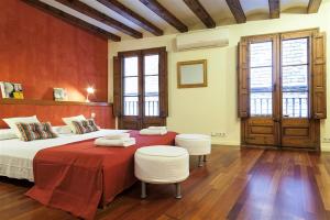 バルセロナにあるFriendly Rentals Manelのベッドルーム1室(大型ベッド1台、白い椅子2脚付)