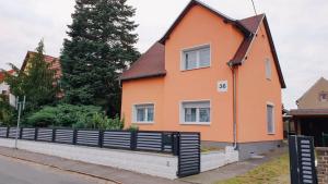 a orange house with a fence in front of it at Villa Wundervoll in Dahlen