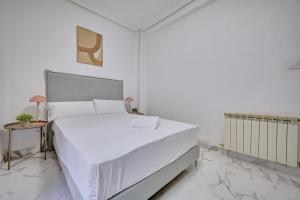 a white bedroom with a large bed with white sheets at Villanueva by clabao in Logroño