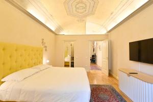 a bedroom with a bed and a flat screen tv at LA CASA DI MONIC in Pisa
