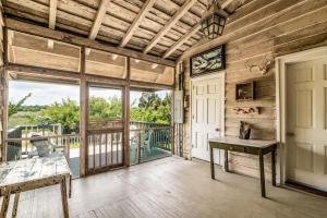 a room with a door and a table on a balcony at Historic Bliss on Pawleys Island's Shoreline in Pawleys Island