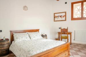 a bedroom with a bed and a table and a window at Dimora Perla di Villa - Historical Wine Retreat near Bernina Express in Villa di Tirano