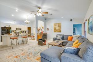 a living room with a blue couch and a kitchen at North Port Home with Charming Lanai about 7 Mi to Beach in North Port