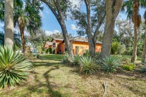 a house with trees and plants in the yard at North Port Home with Charming Lanai about 7 Mi to Beach in North Port