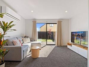 a living room with a couch and a tv at Spa Hideaway in Central City with Parking in Christchurch