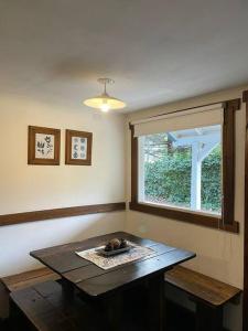 Zimmer mit einem Holztisch und einem Fenster in der Unterkunft La casita azul in San Martín de los Andes