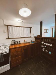eine Küche mit Herd und Spüle in der Unterkunft La casita azul in San Martín de los Andes