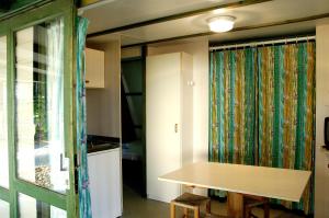 Habitación con mesa y ventana con cortina en Camping As Cancelas, en Santiago de Compostela