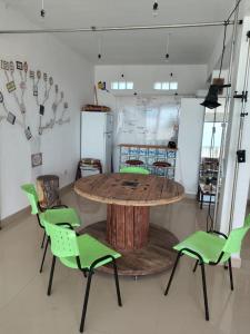 a table with green chairs in a room at Moebius Rada Tilly in Rada Tilly