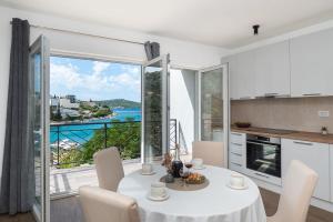 a kitchen and dining room with a view of the ocean at Apartments Kate in Ražanj