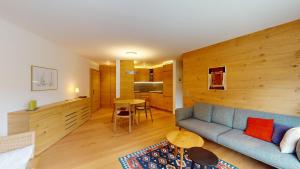 a living room with a blue couch and a table at Abitaziun Traval - Zuoz in Zuoz