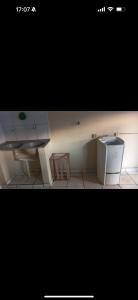 a kitchen with a white refrigerator and a table at Casa Da Mic in Parauapebas