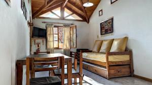 a living room with a bed and a table at Cabañas Willy in El Bolsón