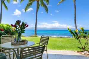 a table and chairs with the ocean in the background at Napili Shores I174 in Kapalua +27 photos