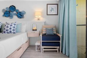 a bedroom with a bed and a chair and a desk at Napili Shores I174 in Kapalua