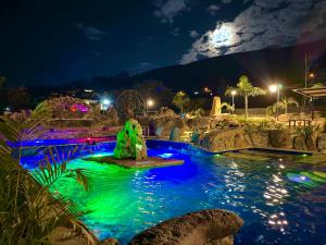 a pool at night with a water park at Hotel Casa Cantabria Campestre in Villa de Leyva