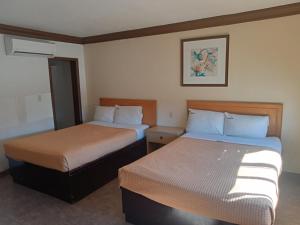 une chambre d'hôtel avec deux lits dans une chambre dans l'établissement Hotel Coronado, à Ensenada