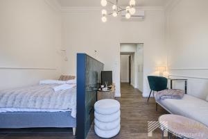 a bedroom with a bed and a couch at Polonia Residence Glamour by LookAp in Łódź