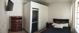 杜伊塔马Hotel Esmeralda Duitama的一间卧室配有一张床,并设有一个通往衣柜的门