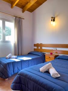 a bedroom with three blue beds in a room at Can Pep Yern 3 in Playa Migjorn