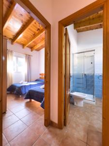a bedroom with a bed and a bathroom with a toilet at Can Pep Yern 3 in Playa Migjorn