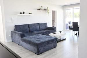a living room with a blue couch and a table at Casa Carlotti in Ponte de Vagos