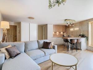 a living room with a couch and a table and a kitchen at Le Barral in Voiron