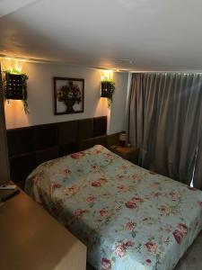 a bedroom with a bed with a floral comforter at Tamandaré Holiday Flat Beira-Mar Apartamento 107 in Tamandaré +28 photos