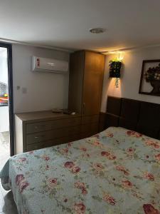a bedroom with a bed and a dresser at Tamandaré Holiday Flat Beira-Mar Apartamento 107 in Tamandaré