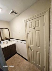 a bathroom with a white door and a sink at Nice bedroom in Lincoln with shared bathroom 1 in Lincoln