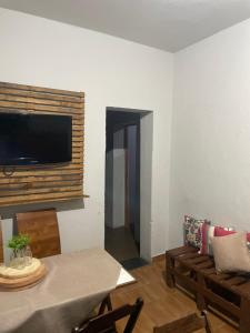 a living room with a table and a television on a wall at Hostel do atleta in Belo Horizonte