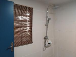 a shower stall in a bathroom with a window at Le Lodge - maison mitoyenne 2 chambres - petit jardin et terrasse in Cayenne +13 photos