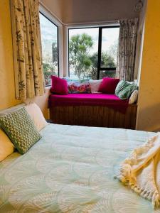 - une chambre avec un lit et une fenêtre avec un canapé dans l'établissement Ōmāpere Bach, à Omapere