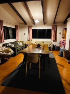 un salon avec une table et un canapé dans l'établissement Ōmāpere Bach, à Omapere