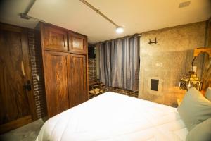 a bedroom with a large bed and a wooden cabinet at Romance en San Miguel in San Miguel de Allende