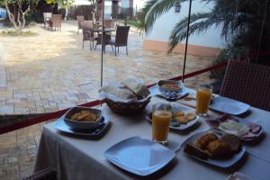 a table with plates of food and glasses of orange juice at Casa Antiga in Odeceixe