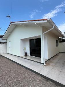 ein weißes Gebäude mit einem großen Fenster in der Unterkunft Refúgio da Camboa - Casa Menta in Governador Celso Ramos