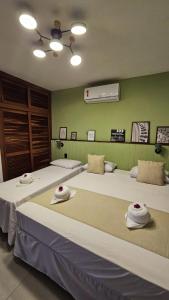 a room with two beds with hats on them at Brisas do Amor Apto 109 in Pipa +37 photos
